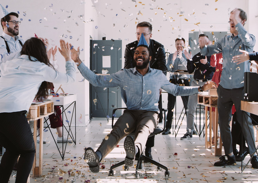 people laughing in the office with confetti